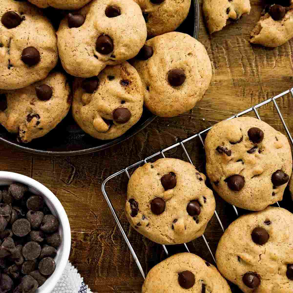 Gluten-free cookies decorated with chocolate chips on a cooling rack.