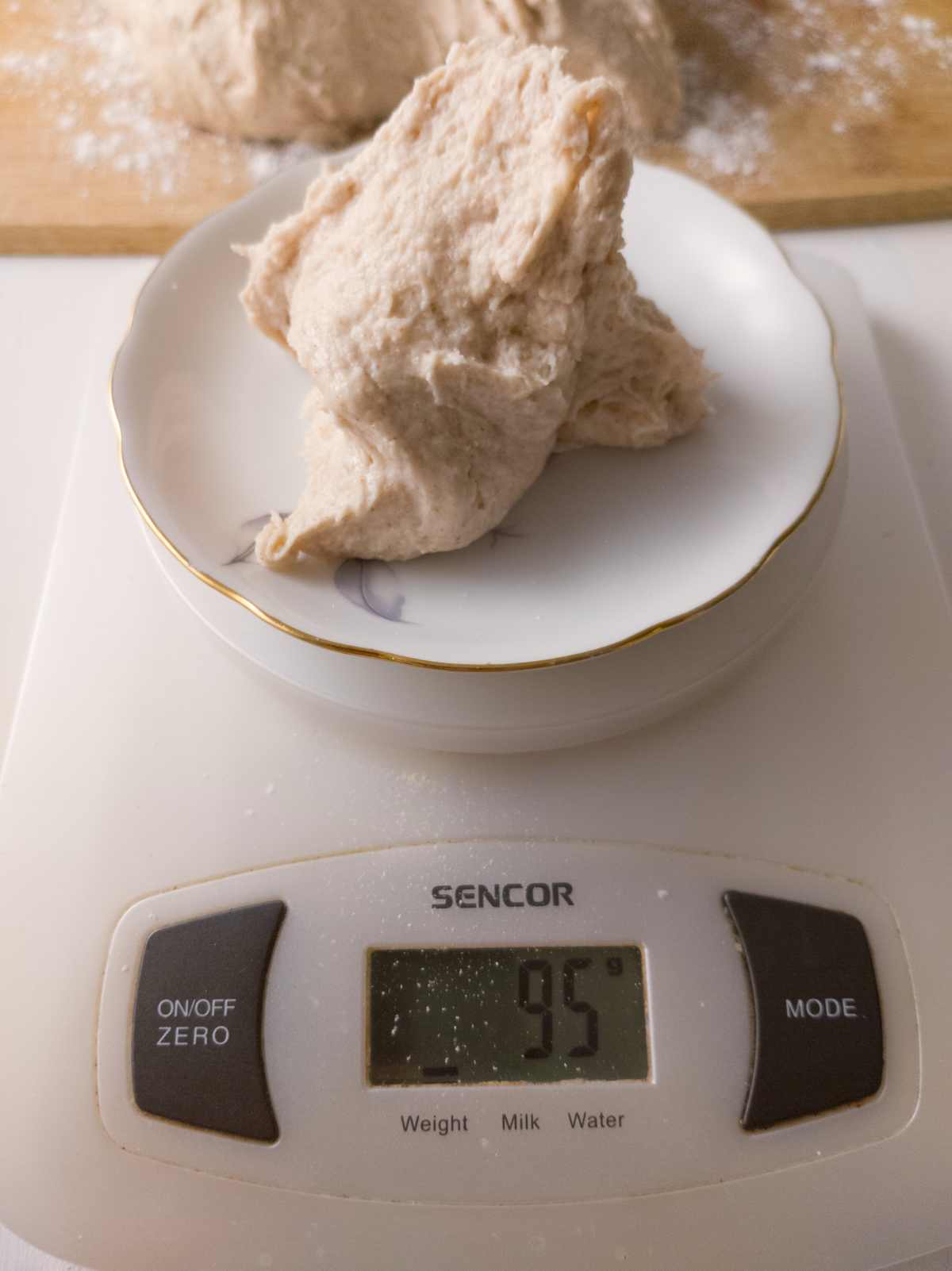 Measuring out the dough for one bowl on a digital scale.