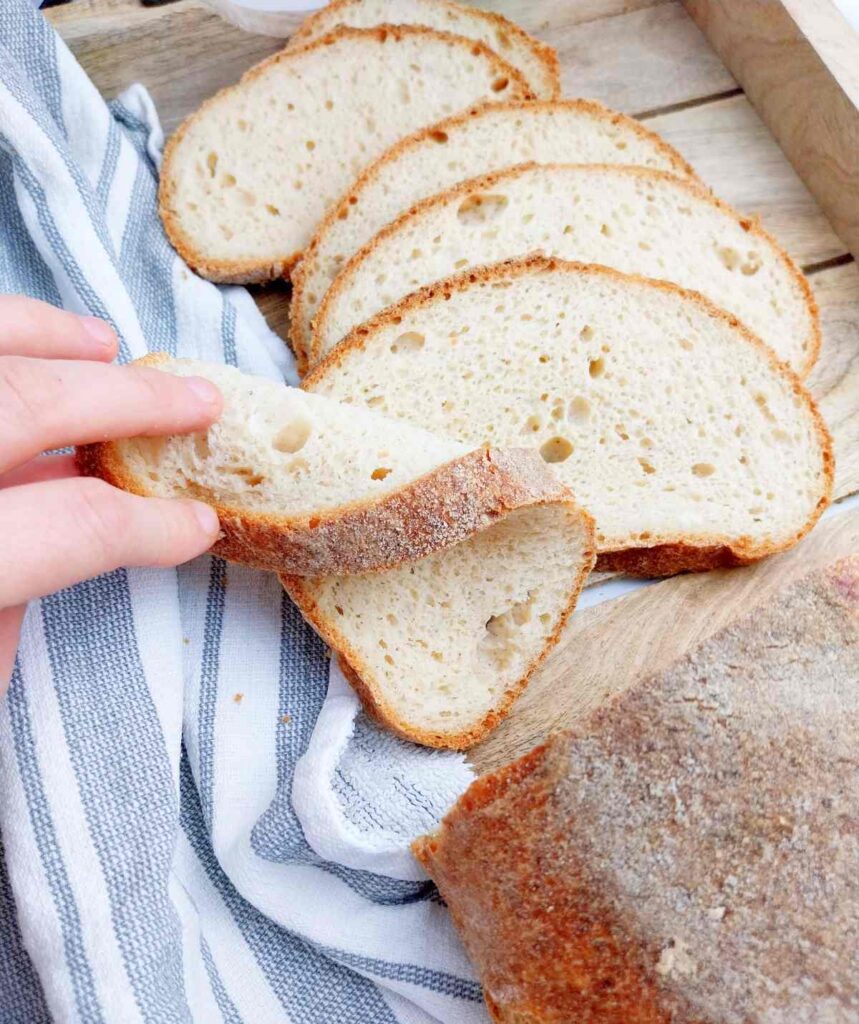 Sliced gluten-free sourdough loaf on a wooden surface.