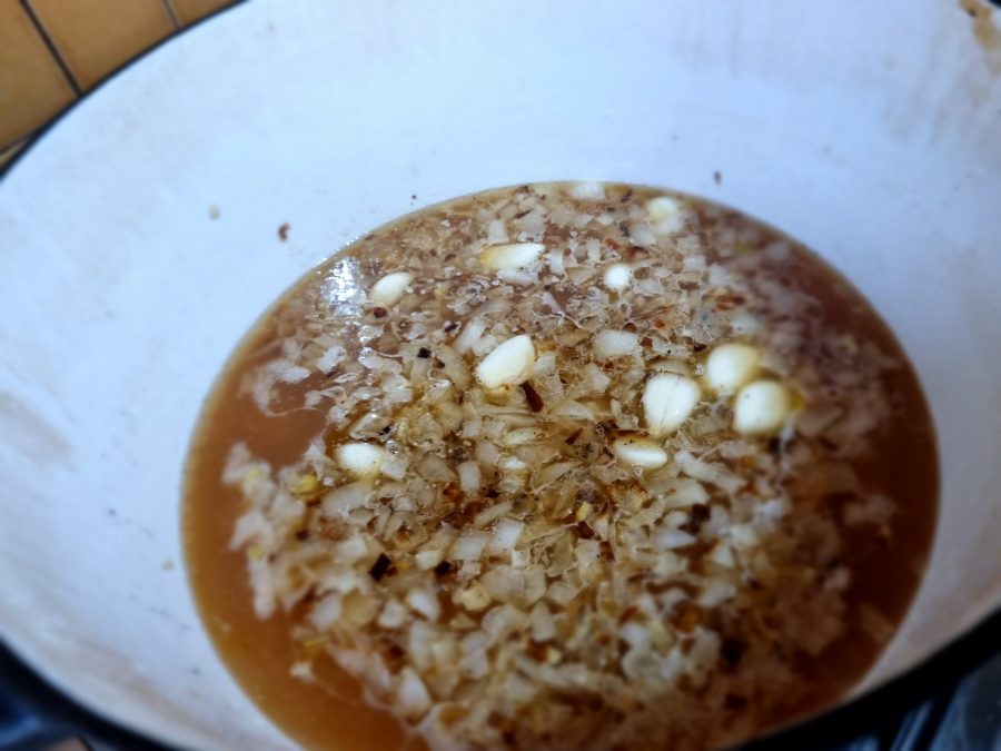 Chicken stock, garlic, onions in a pot.