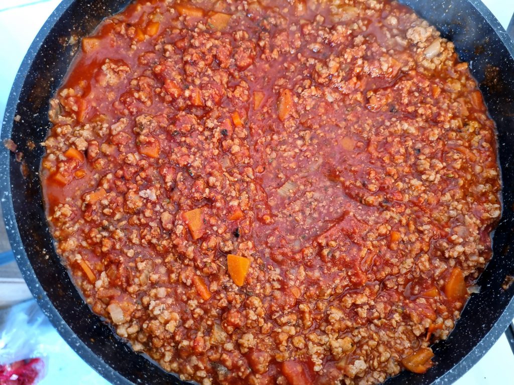 Add tomato products to the bolognese sauce