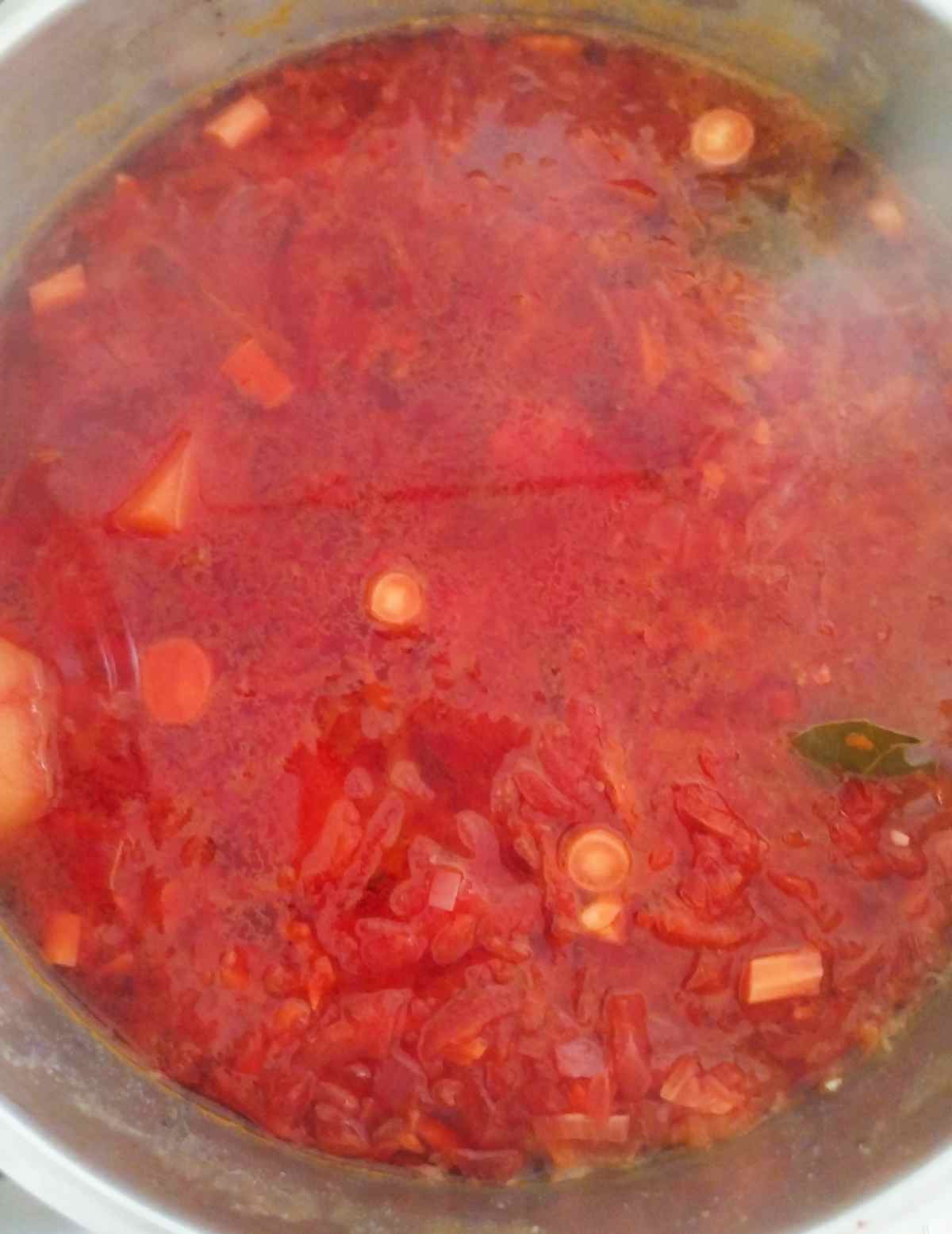 Boiling borscht with all ingredients added.