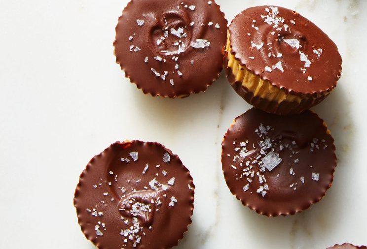 Nut butter cups on a white surface.
