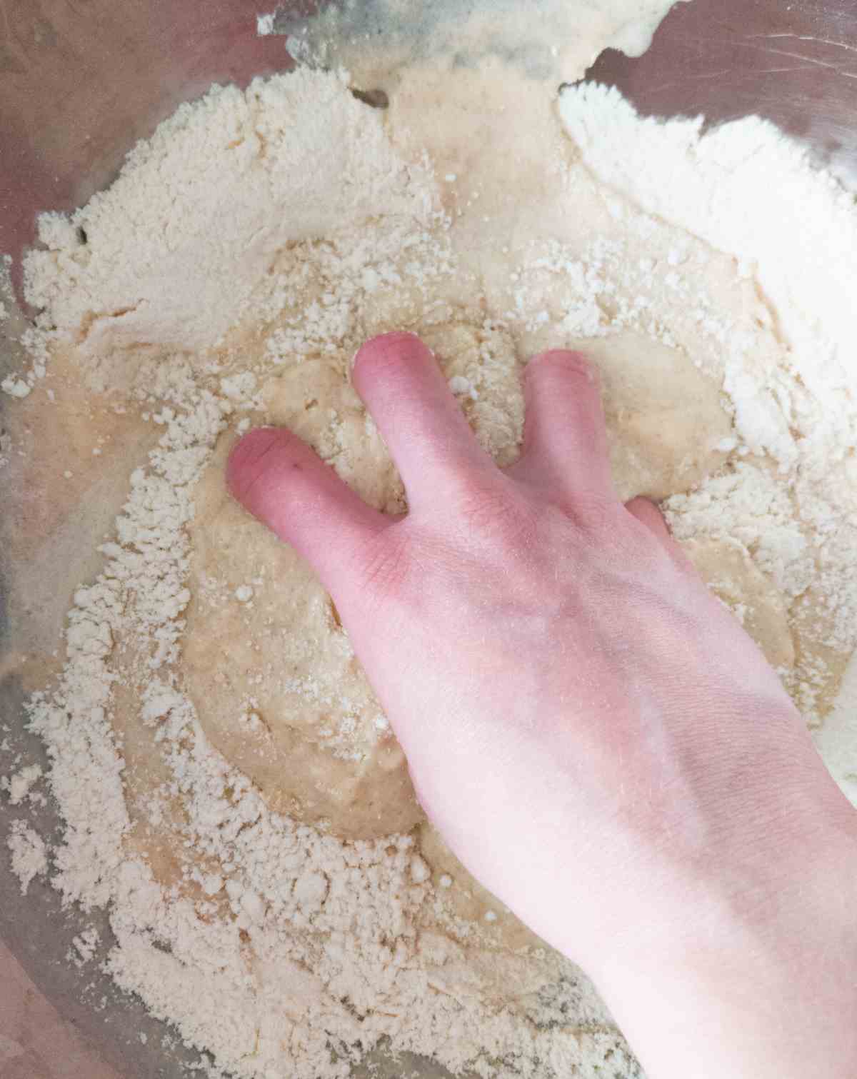 Mixing the dough by hand in a large mixing bowl.