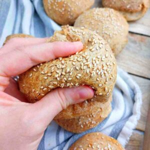 A burger bun squished by a hand.