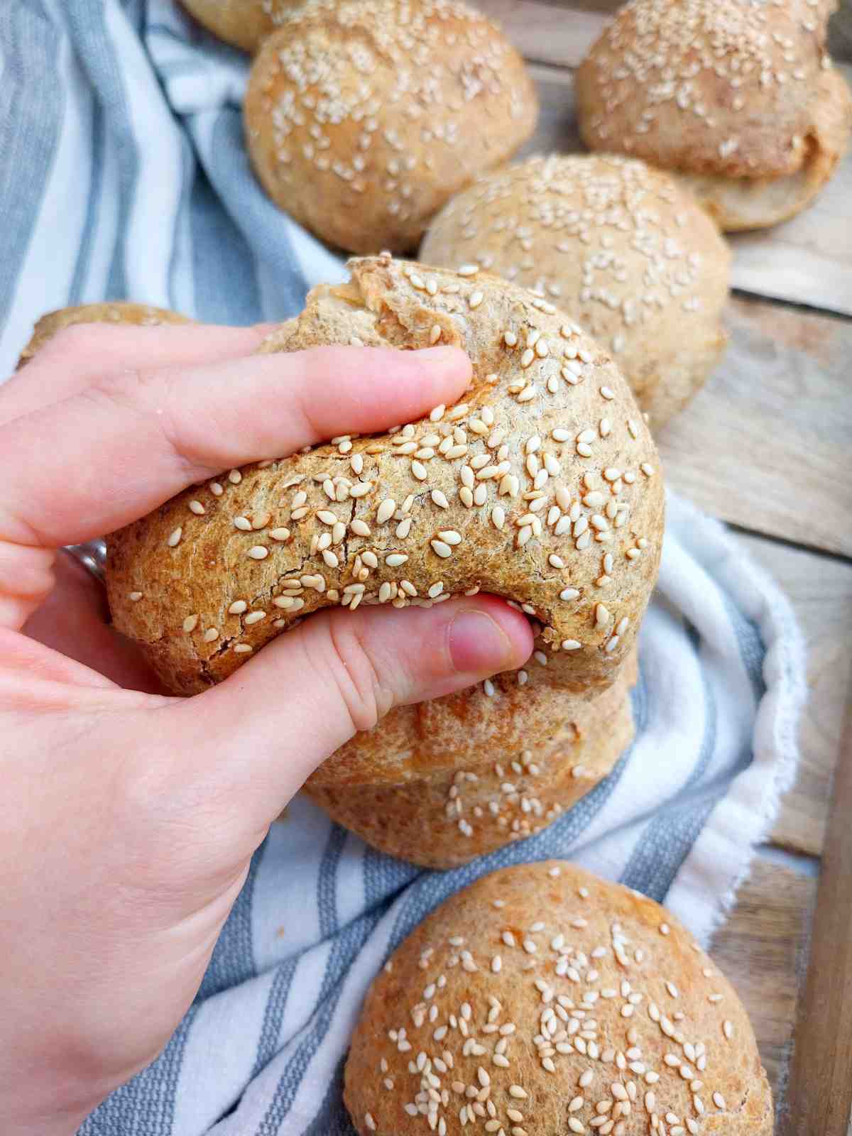A burger bun squished by a hand.