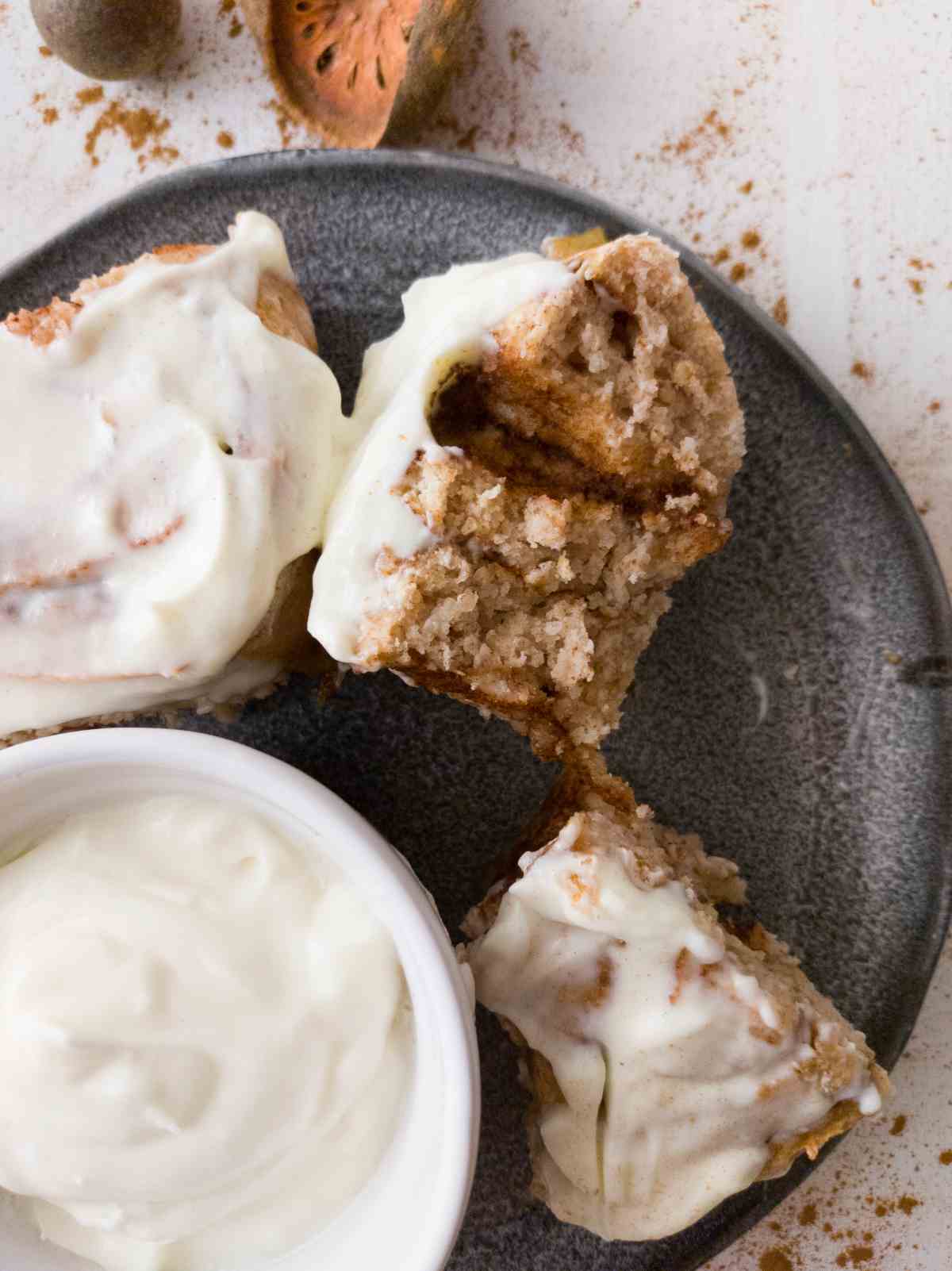 Gluten-free sourdough cinnamon rolls on a plate sliced in half.