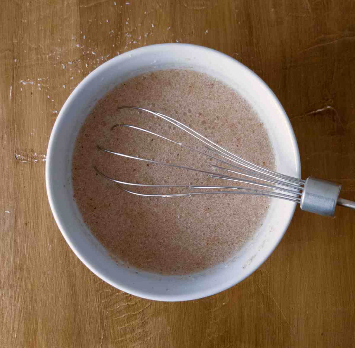 Psyllium husk mixed with water in a small bowl with a whisk.