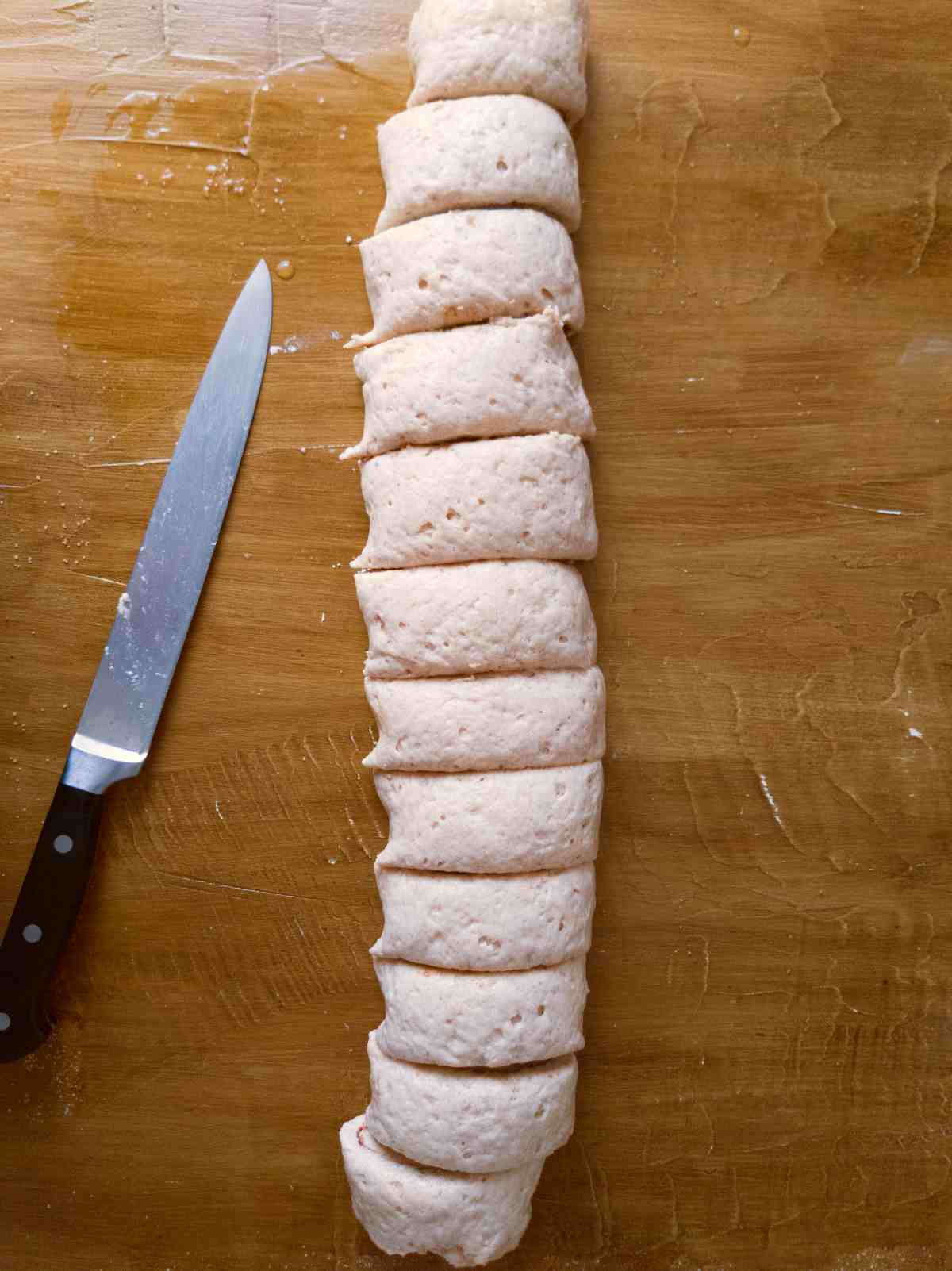 Sliced cinnamon rolls with a knife.