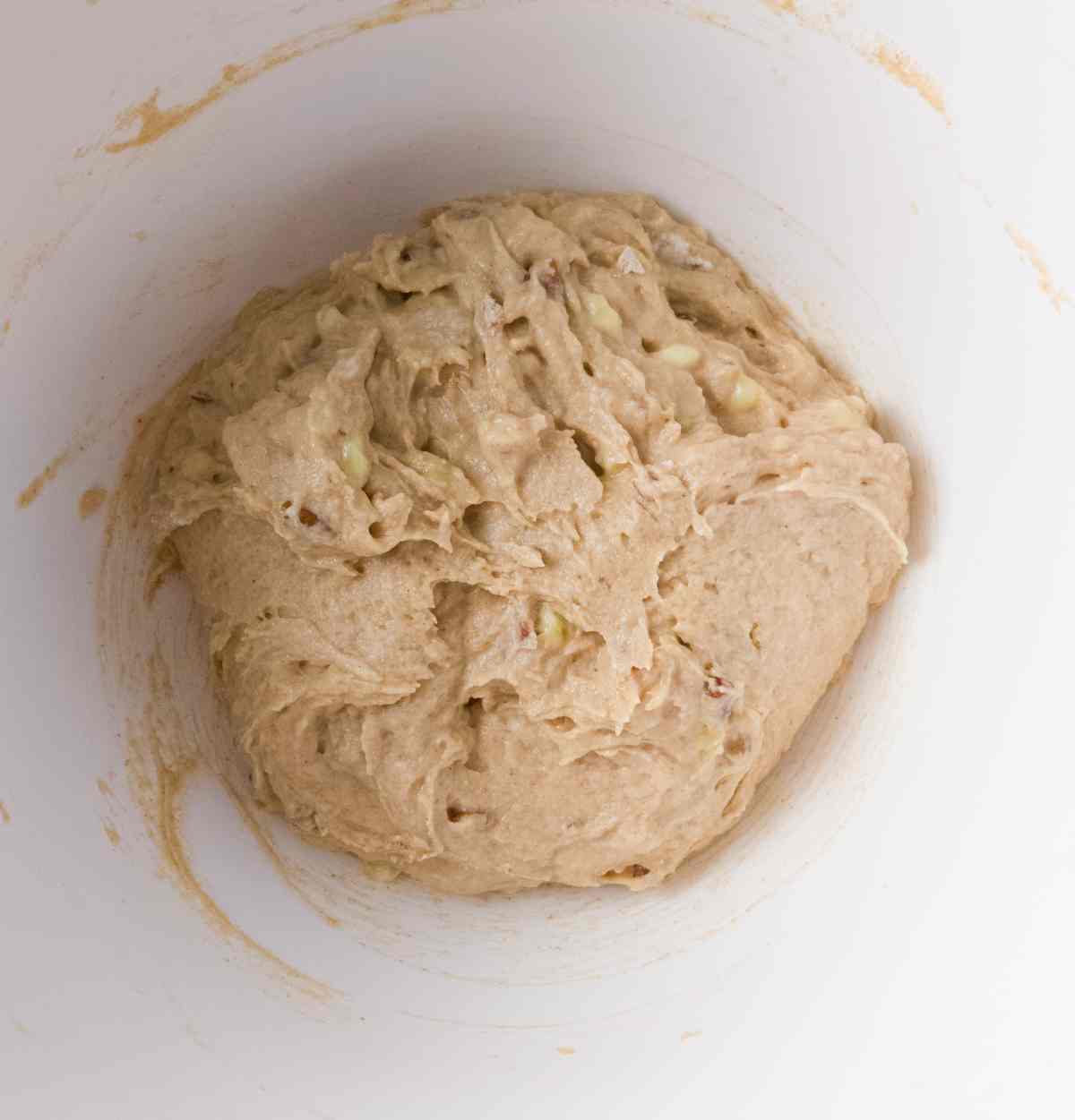 Banana bread batter combined in a mixing bowl before baking.