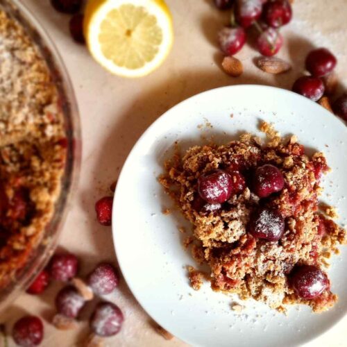 Gluten Free Cherry crumble on a plate next to the bigger dish.