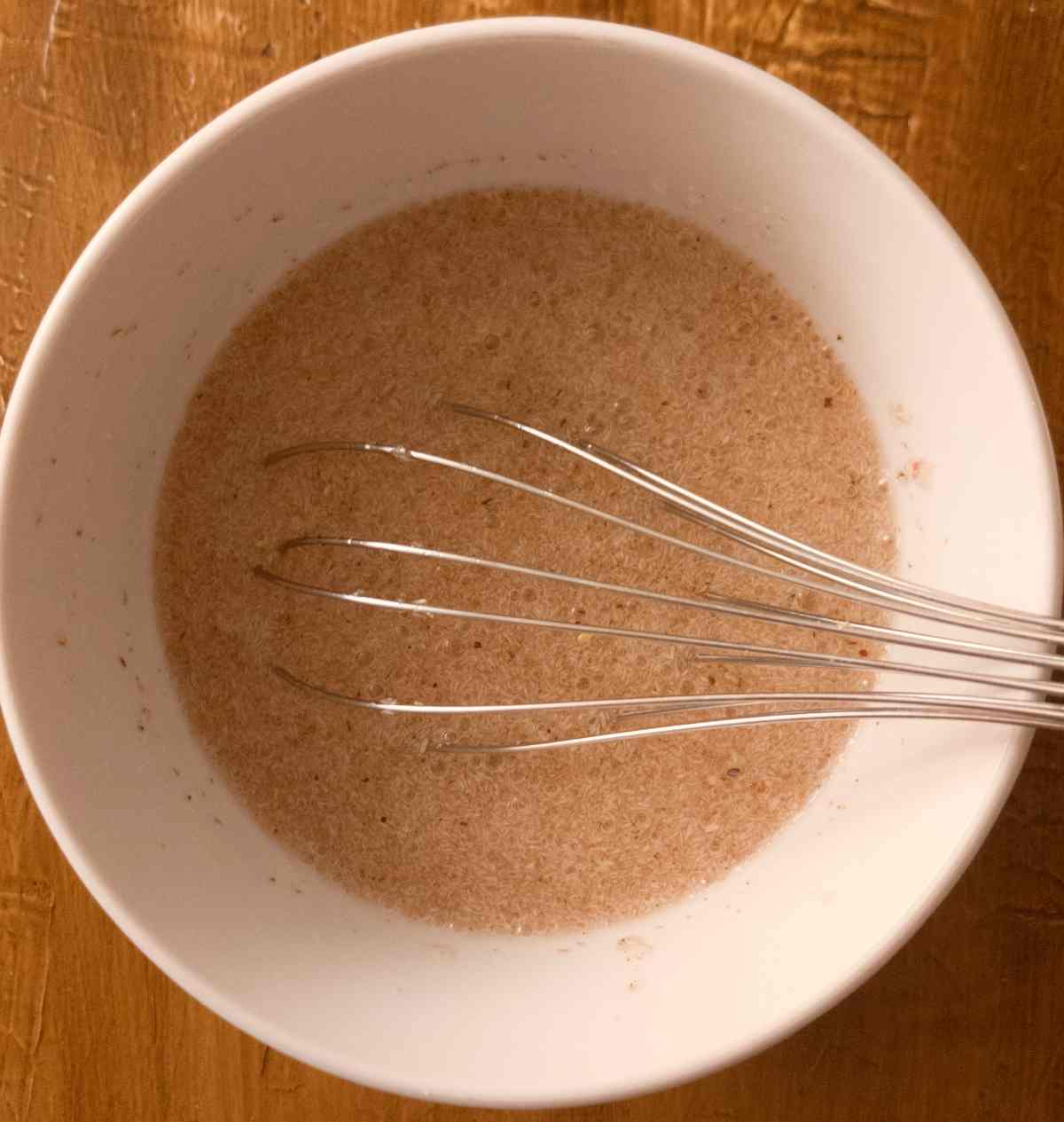 Psyllium husk mixed with water in a small bowl with a whisk.