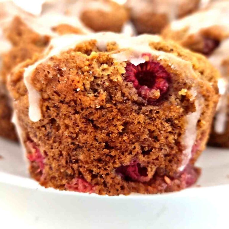 Gluten-free raspberry muffin up close with frosting on top.