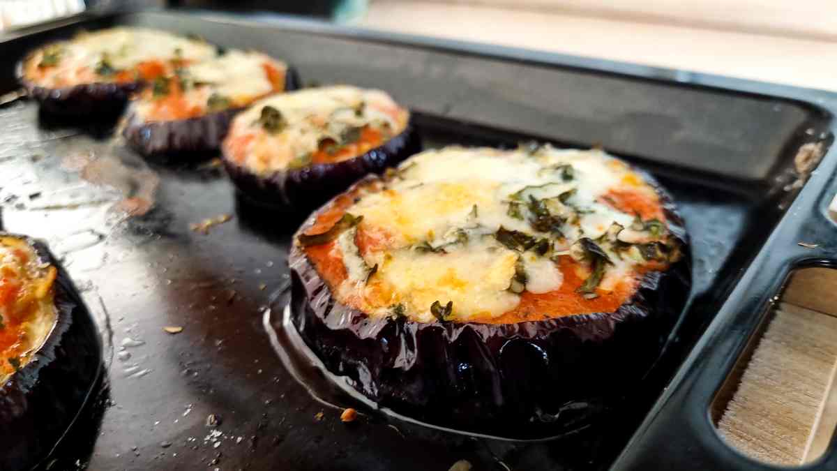 Eggplant crustless pizzas on a baking sheet.