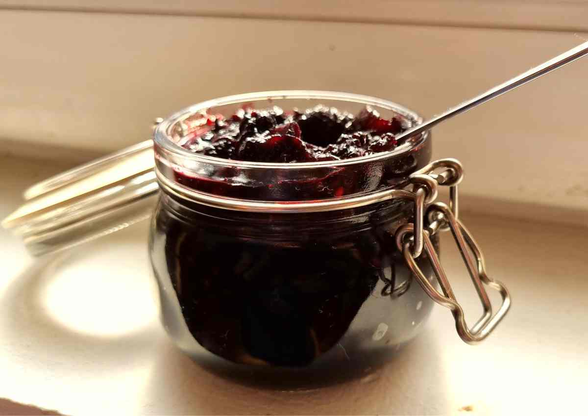 Elderberry Jam in a Small Jar with a Spoon Inside 