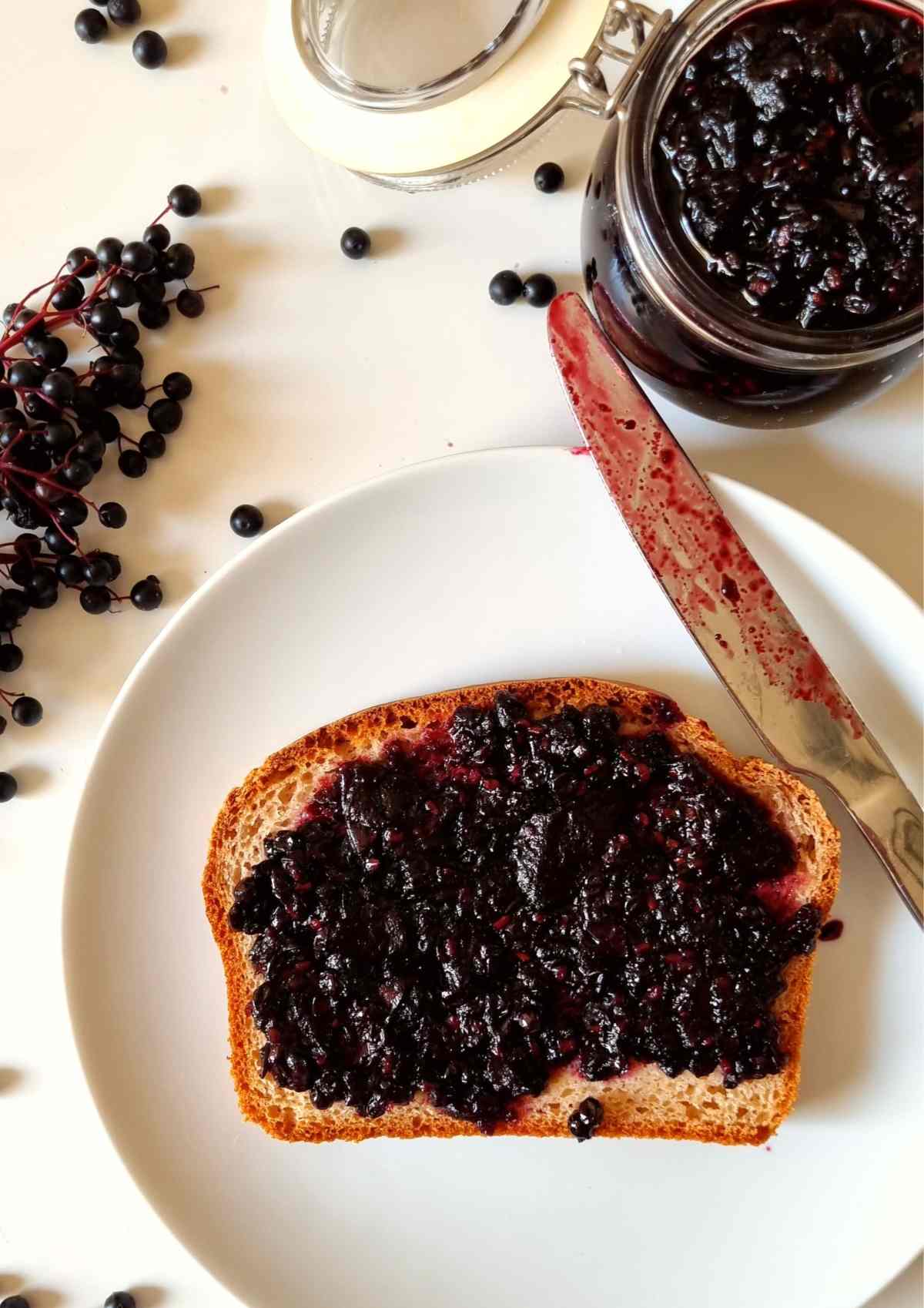 Elderberry Jam spread onto a piece of bread on a plate