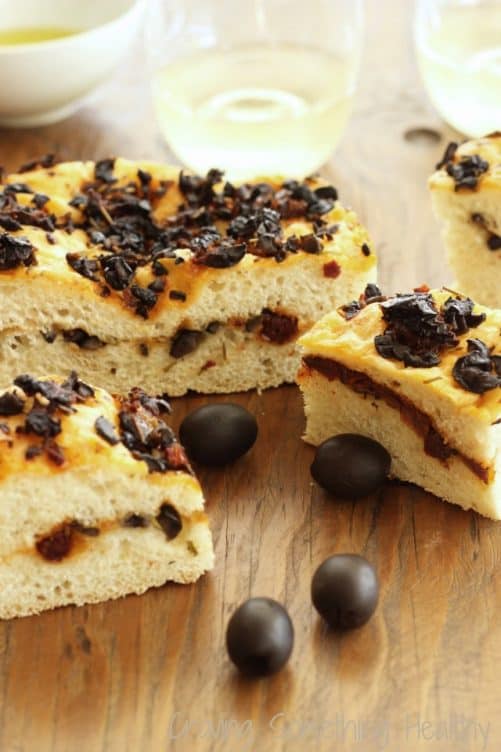Focaccia pieces with black olives on the table.