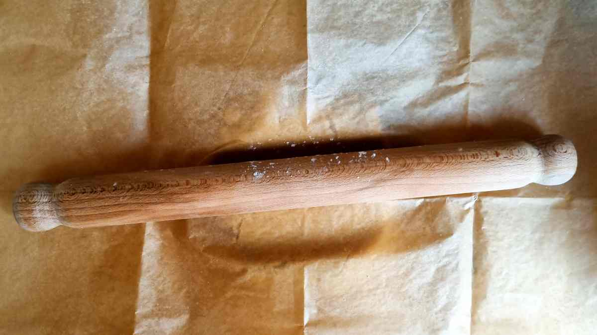Rolling pin on top of parchment paper.