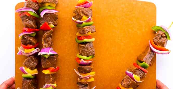 kabobs steak on skewers on a cutting board.