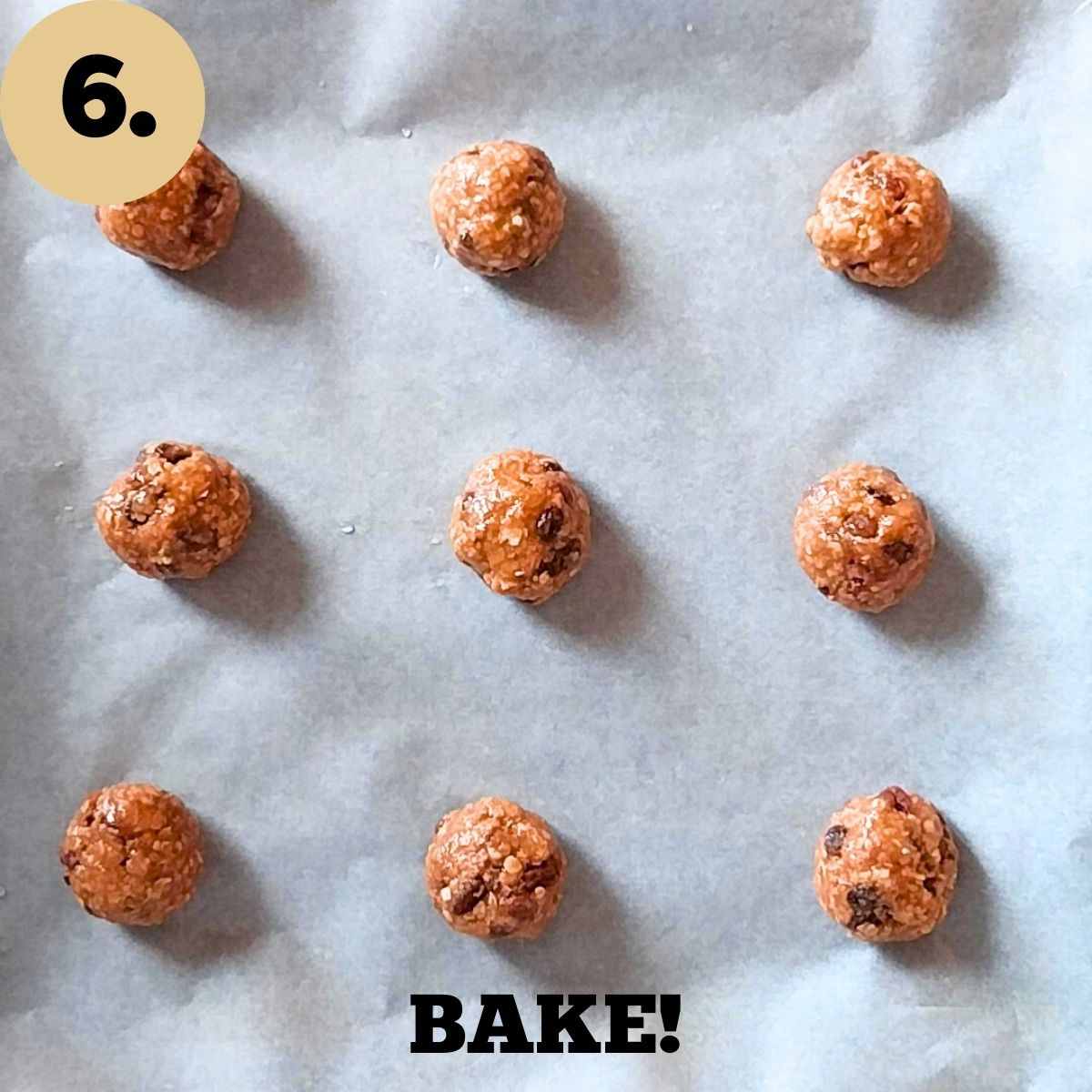 Balls of cookie dough on a baking sheet lined with parchments paper.