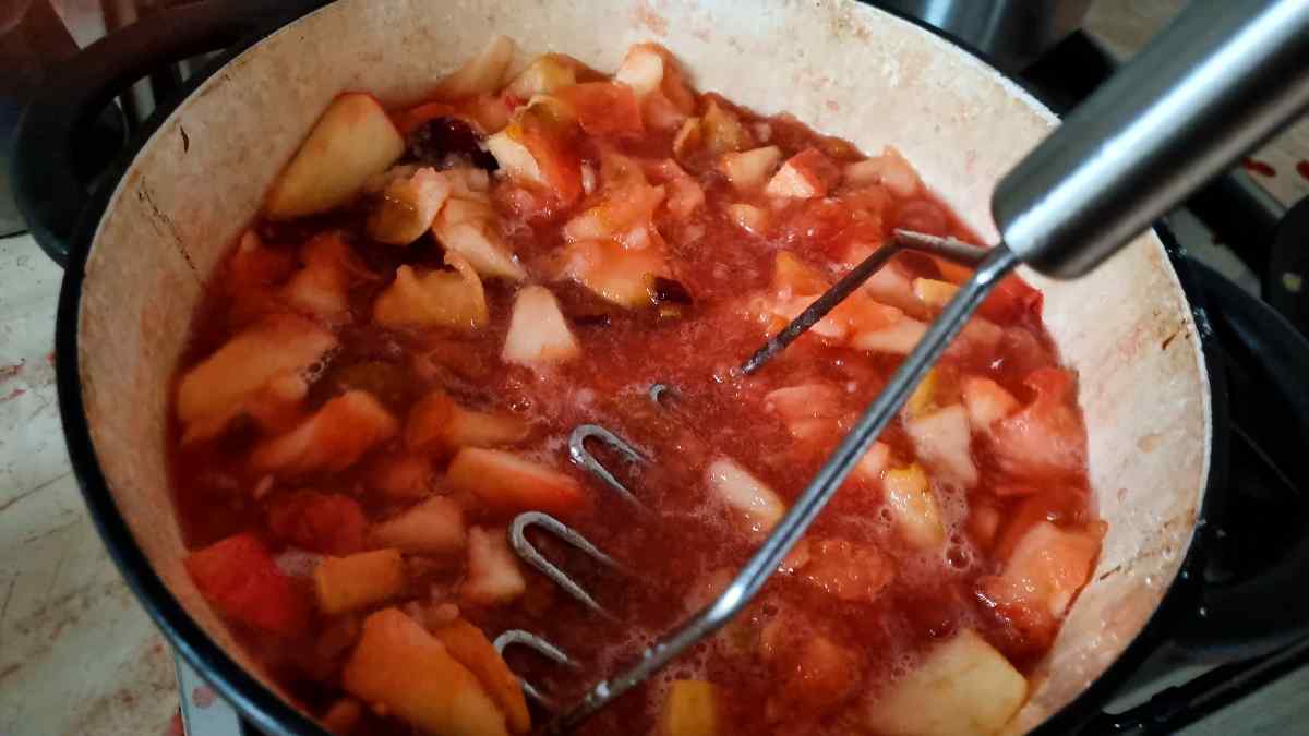 Mashing the fruit in the pot.