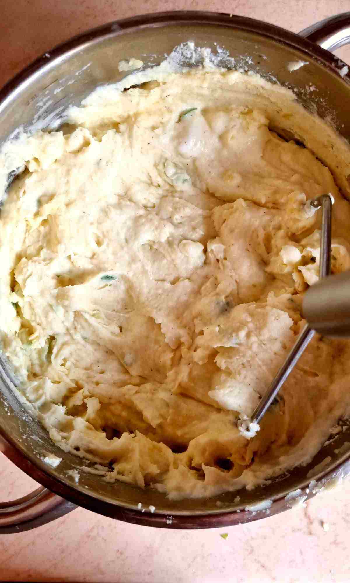 Mixing the mashed potatoes with sour cream.
