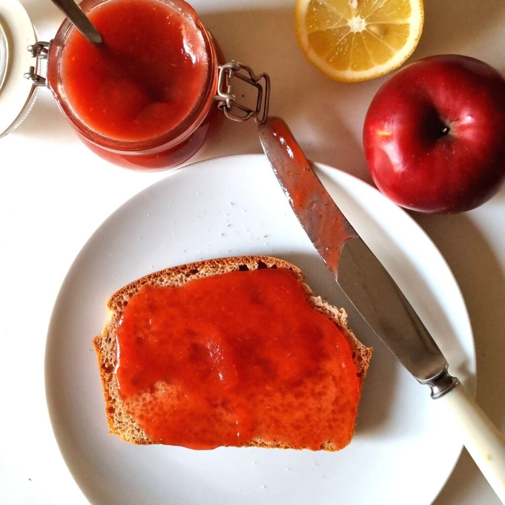 Plum and Apple Jam spread on a piece of bread close up.