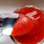 Plum and Apple jam on a spoon close up.