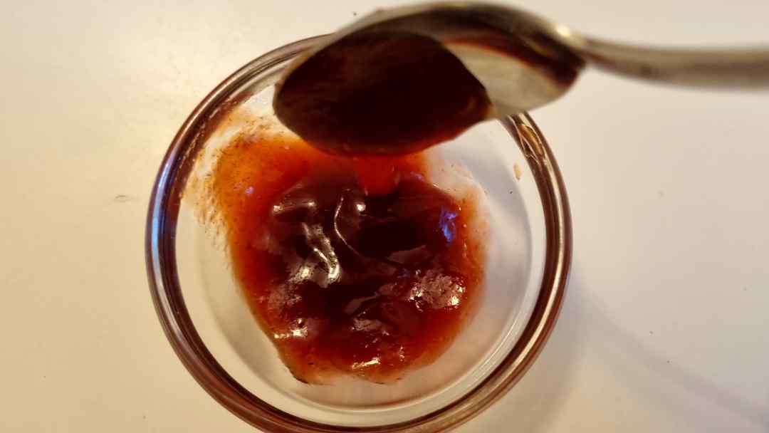 Plum jam on a small spoon