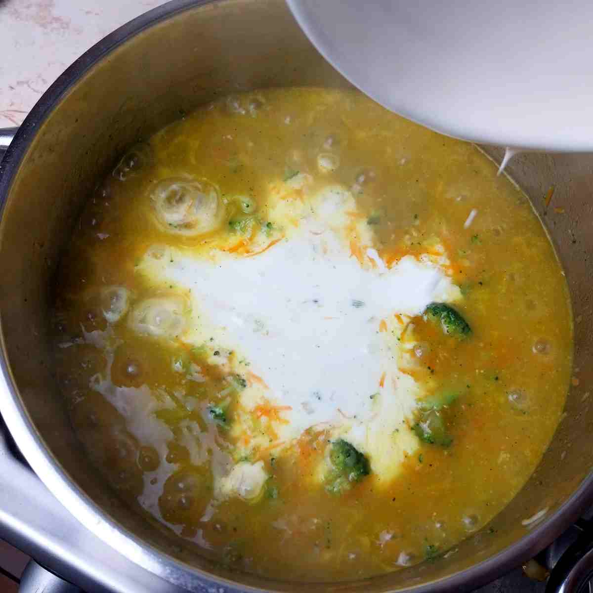 Adding heavy cream to the pot.