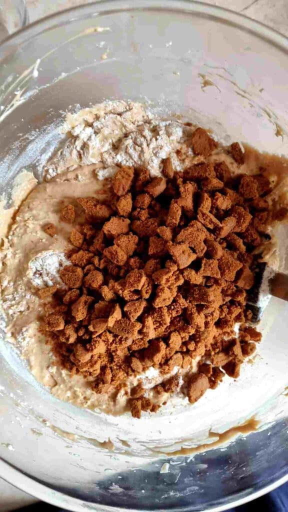 Adding crushed cookies to the batter.