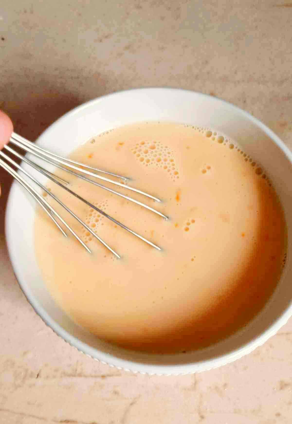Whisking the wet ingredients in a bowl.