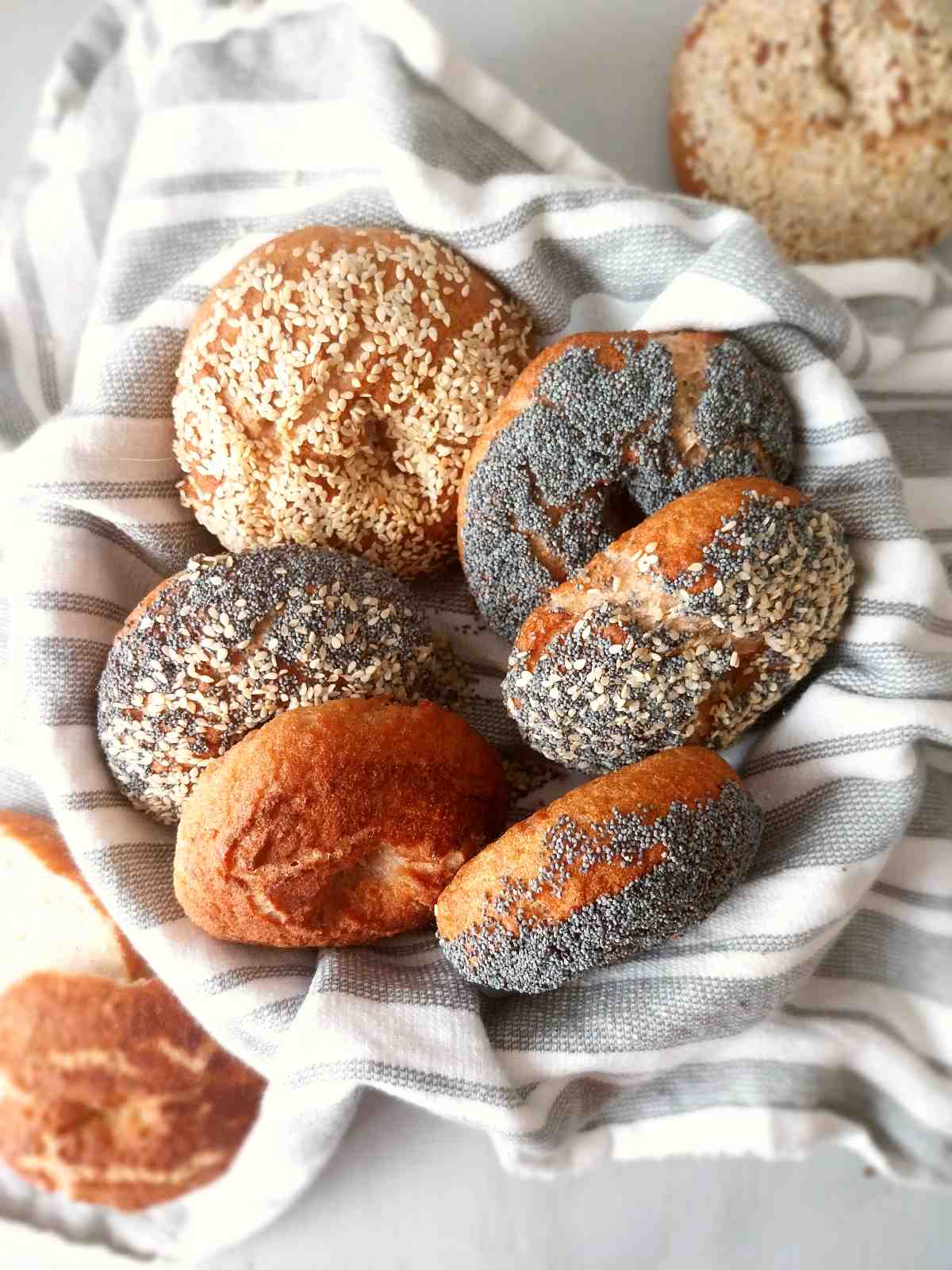 gluten-free sourdough bagels in a large bowl lined with a kitchen towel.