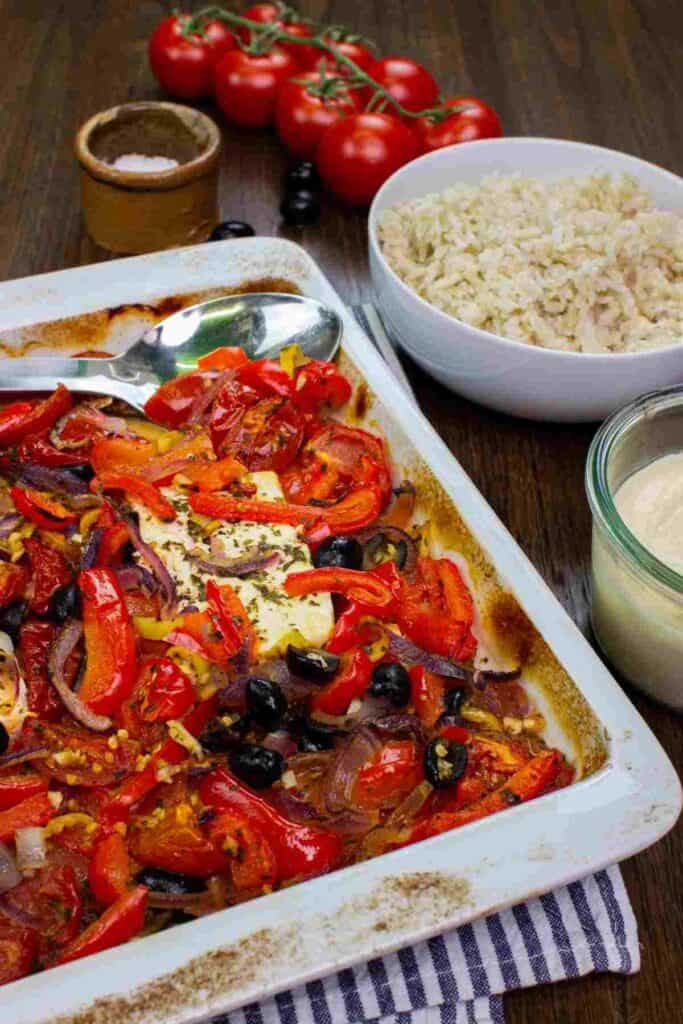 A tray with veggies and feta next to a rice bowl.