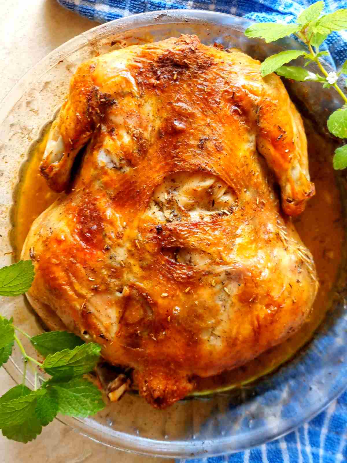 Roasted whole chicken in a dish.