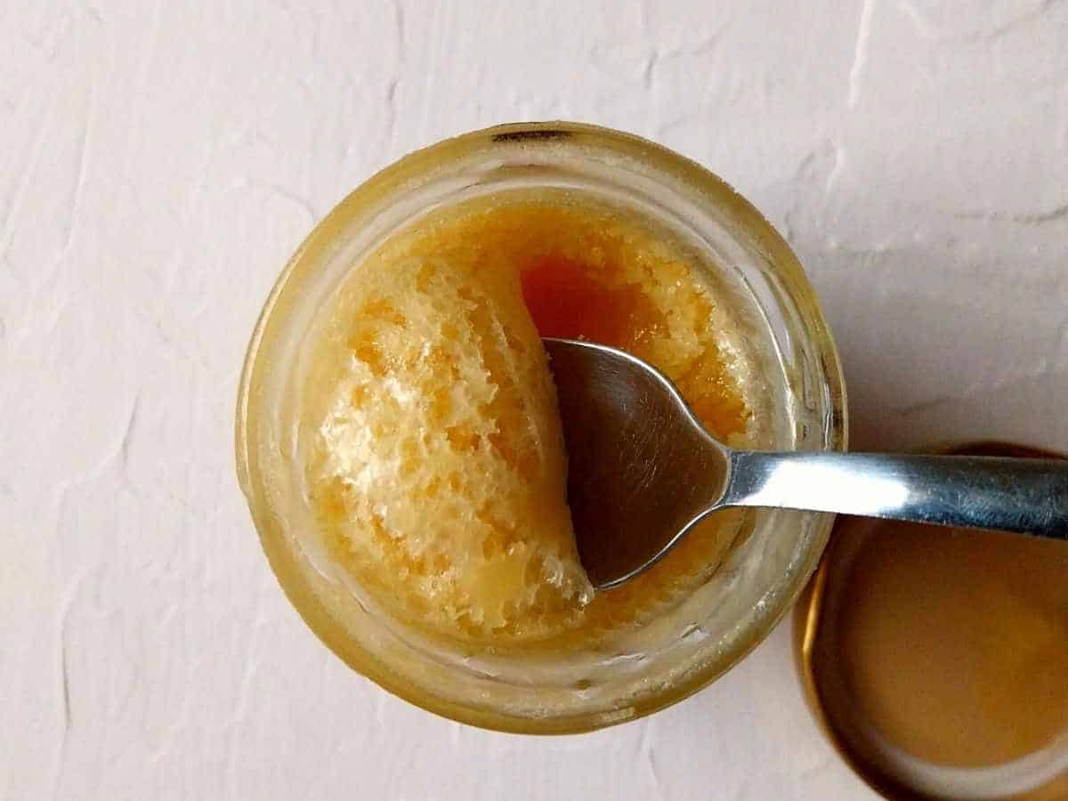 honey with a spoon scooping from the jar.