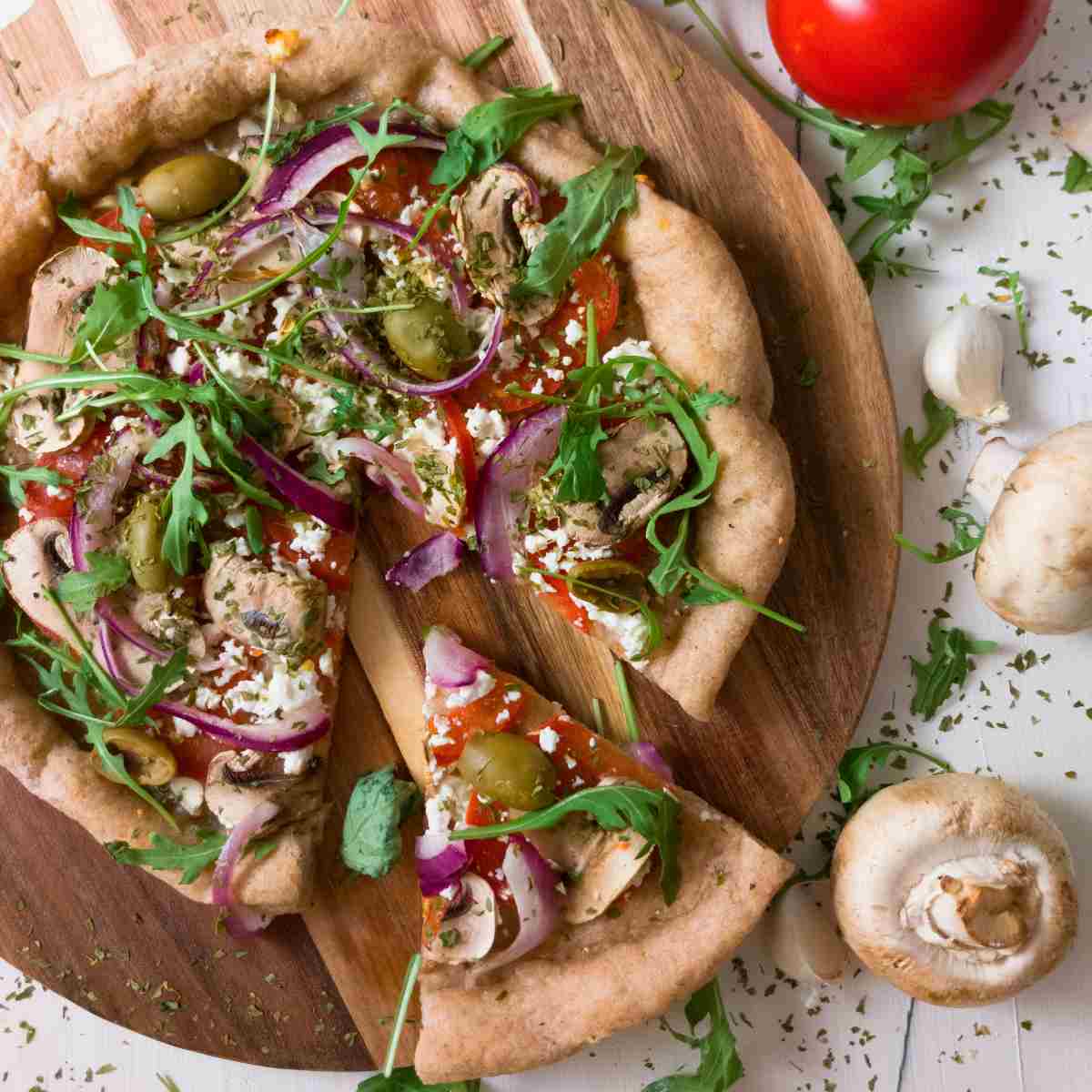 Gluten-free sourdough pizza with a piece cut out.