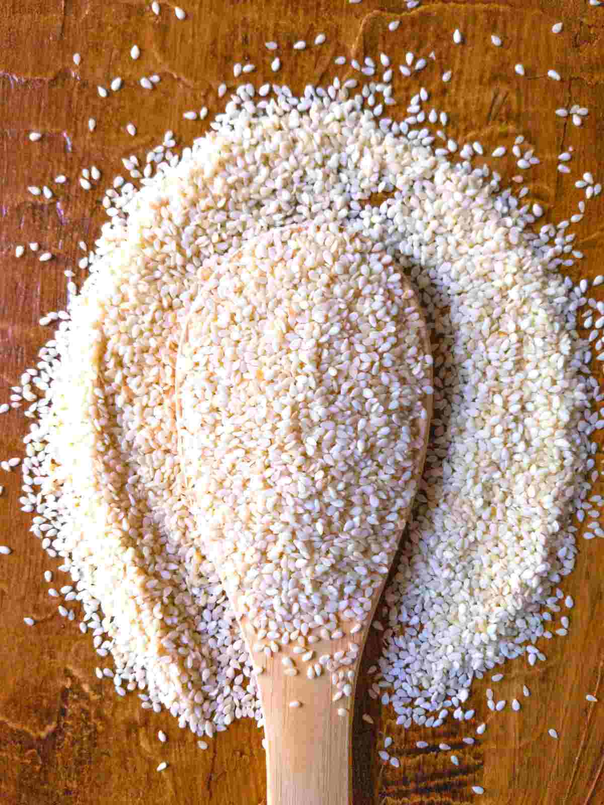 Sesame seeds on a wooden spoon.