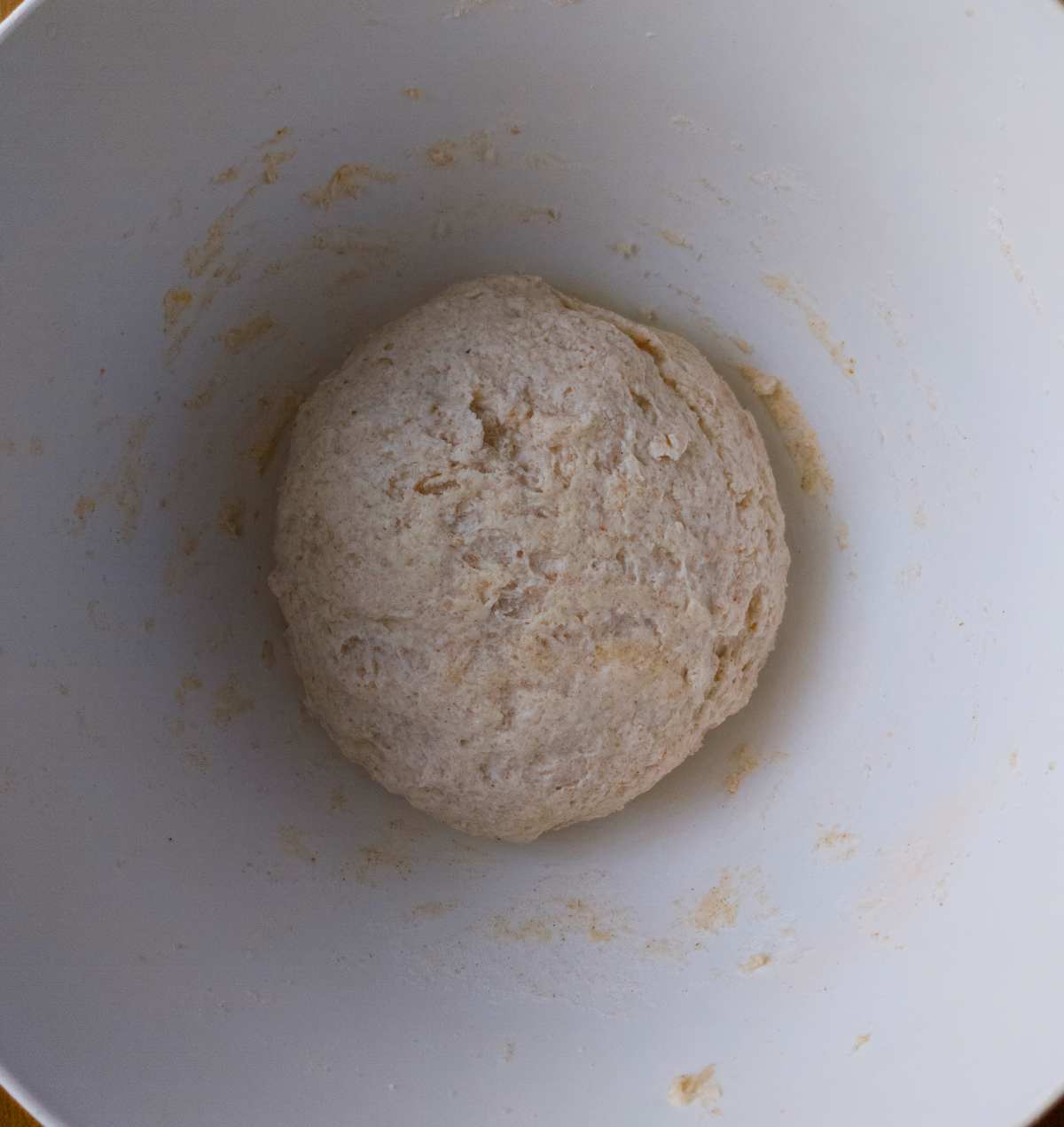 The dough formed into a ball inside the mixing bowl.