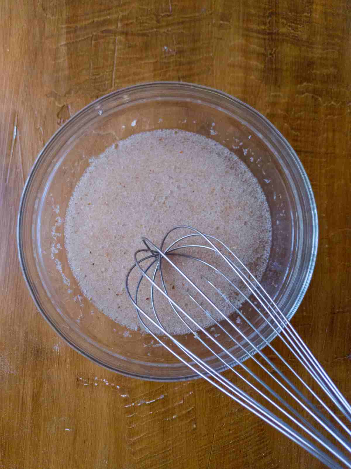 Psyllium husk mixed with water in a glass bowl with a whisk in it.