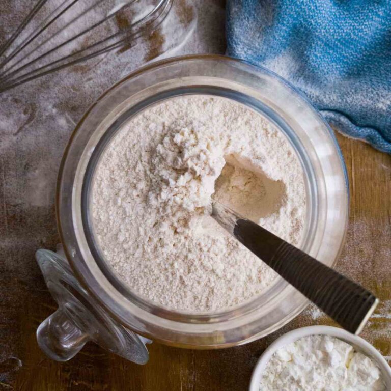 The flour in a glass jar with a spoon in it.