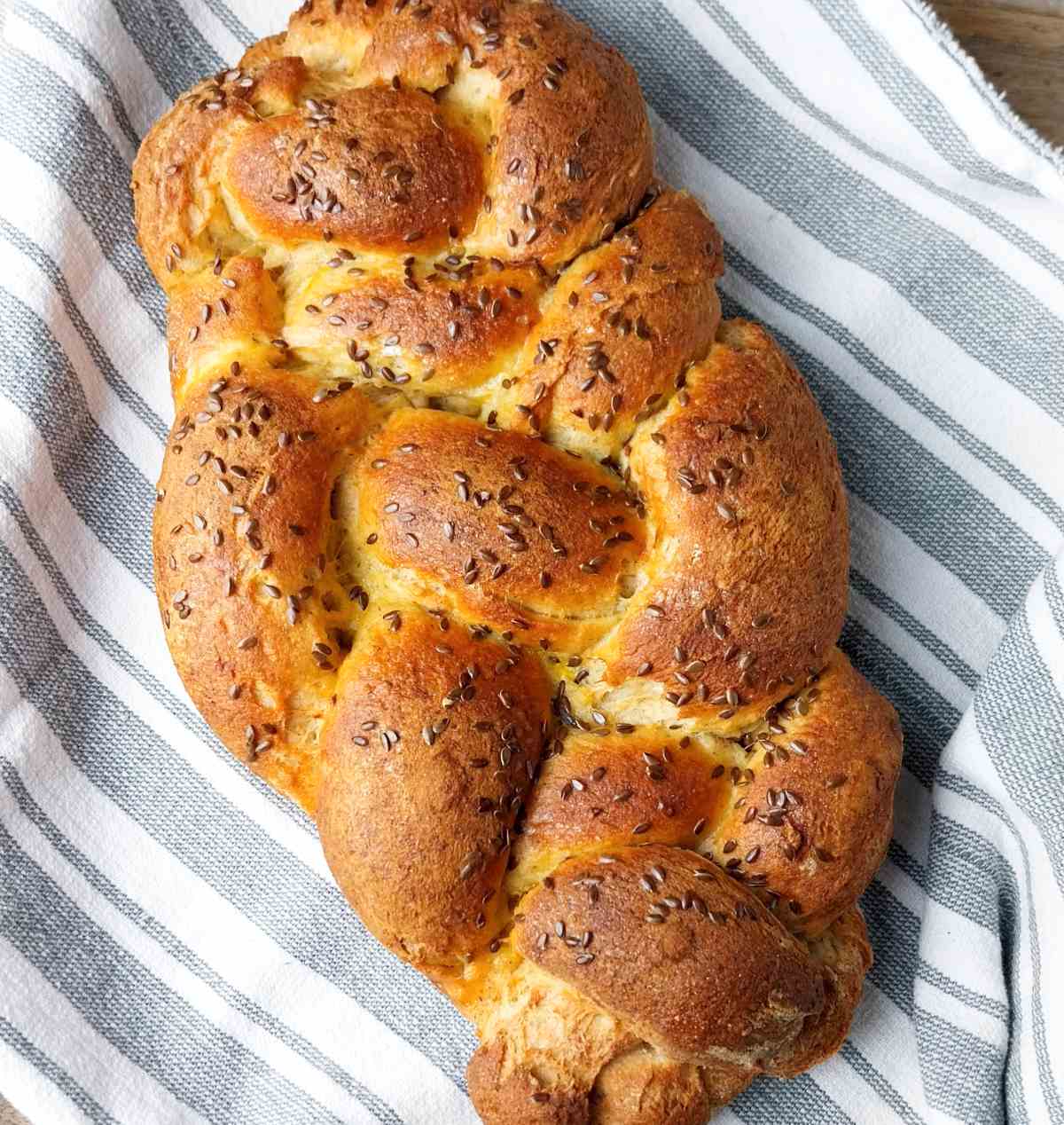 Baked gluten-free sourdough challah on a kitchen towel.