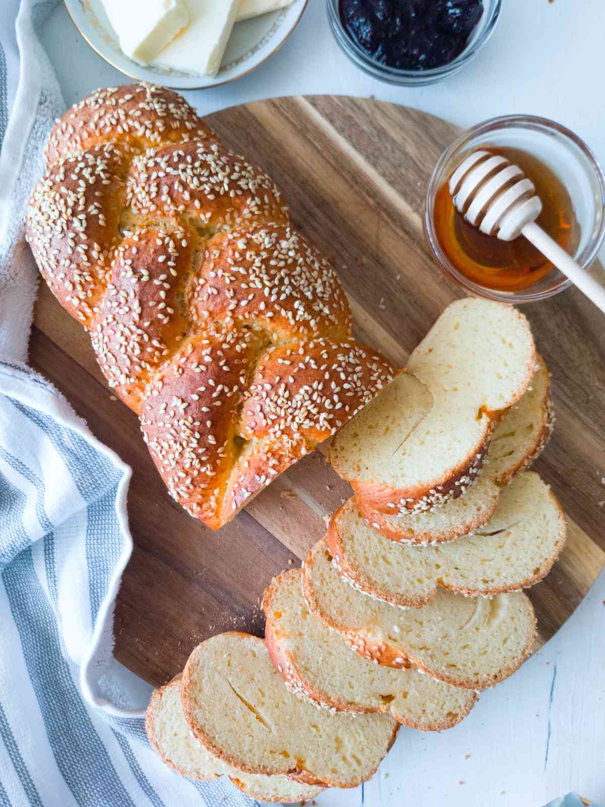 Gluten-free sourdough challah sliced with honey, butter, and jam on the side.