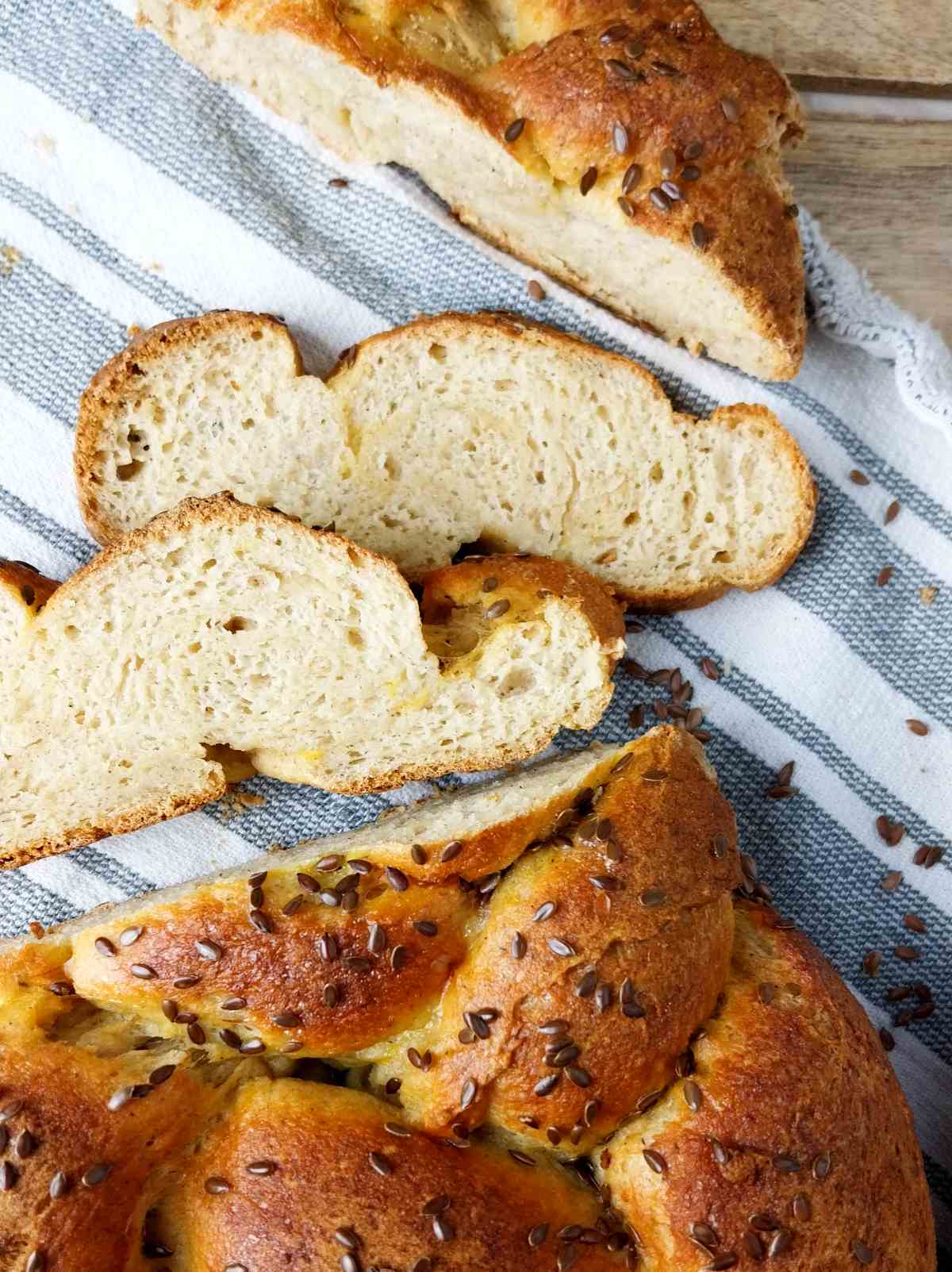 Sliced sourdough challah on a kitchen towel.
