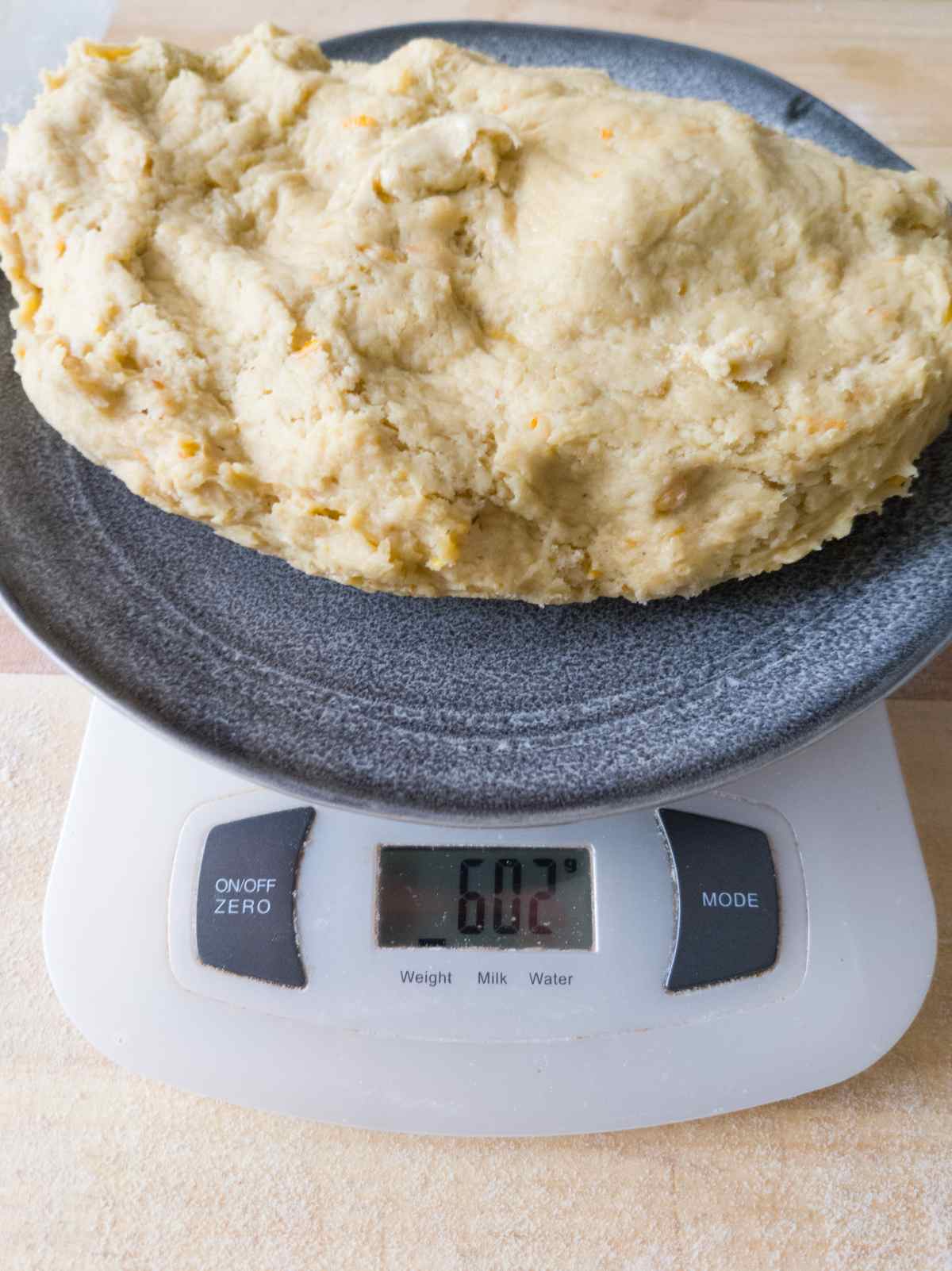 The dough on a plate on a digital kitchen scale.