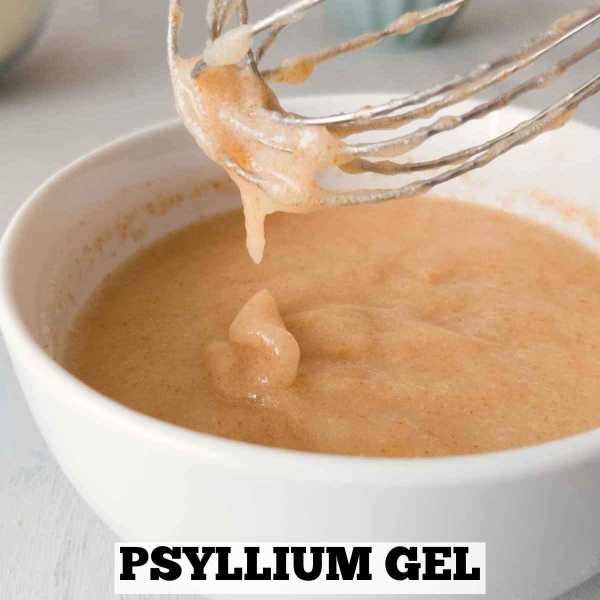 A white bowl with brown psyllium gel with a whisk.