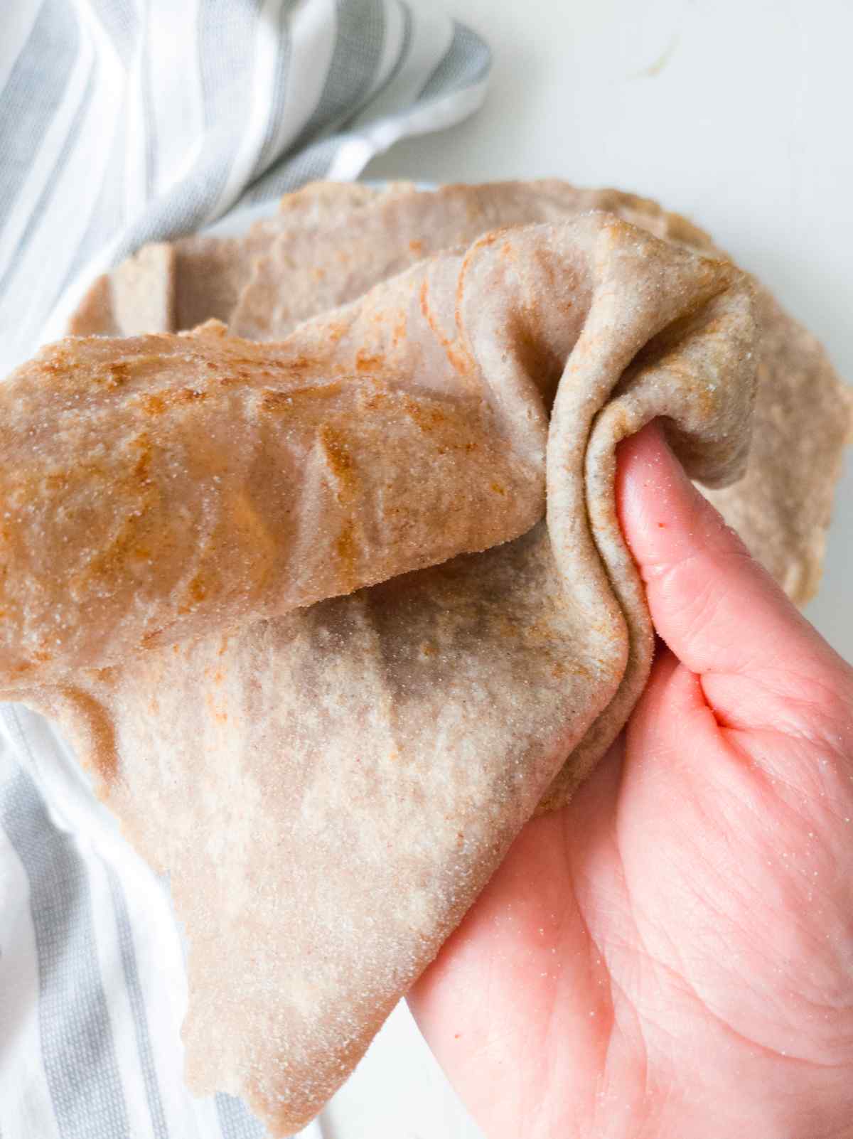 Buckwheat tortilla wrap held by a hand.