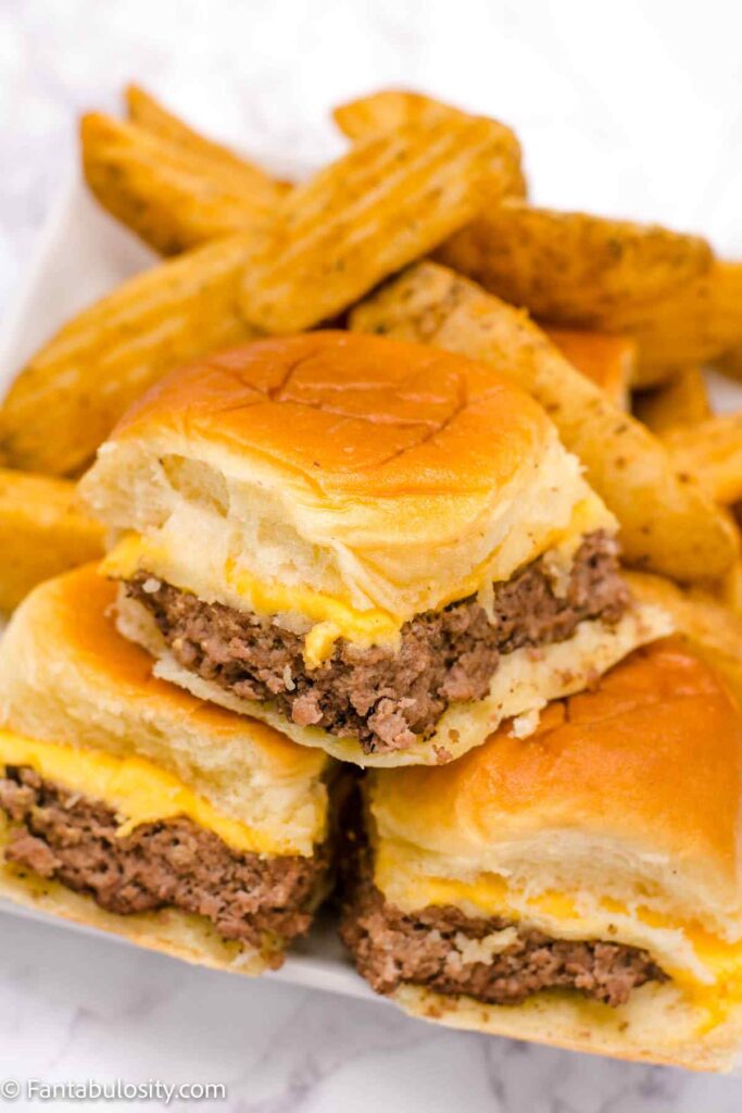 Cheeseburger sliders stacked on a plate.