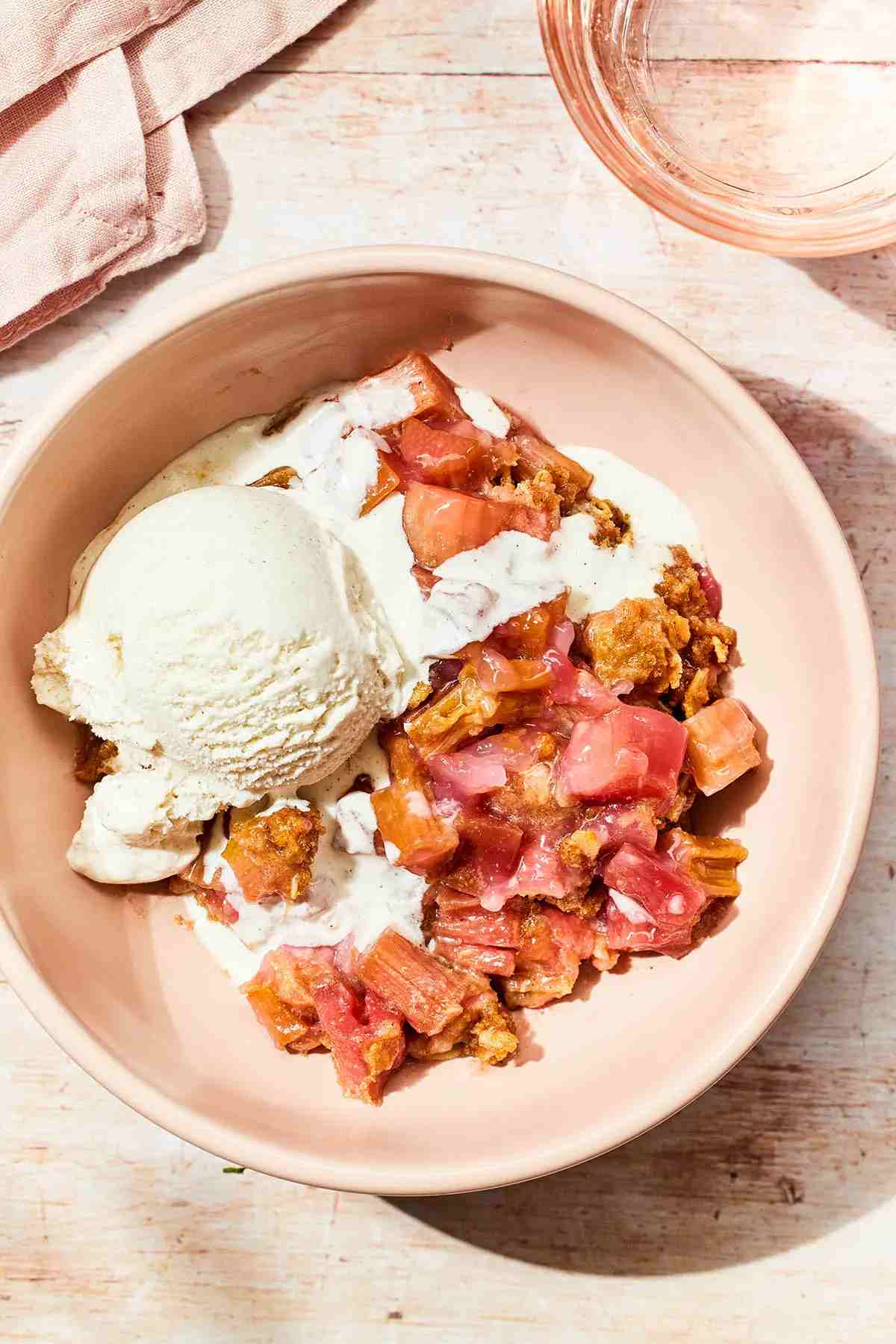 Buckwheat rhubarb crisp on a plate with ice cream.