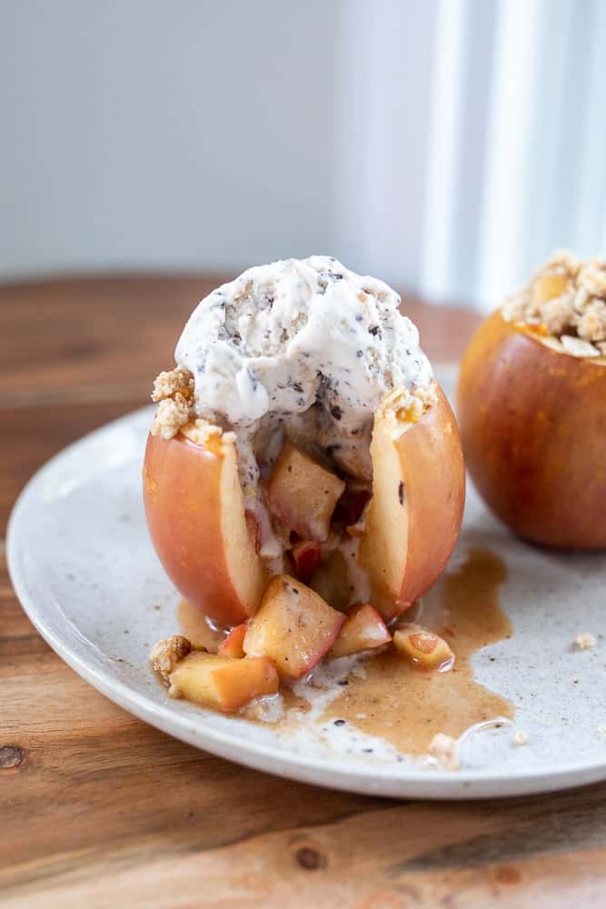 A stuffed baked apple bite with ice cream on top. 